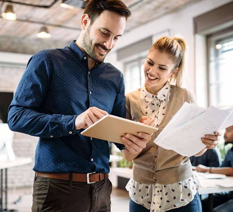 due persone sorridenti in ufficio con tablet